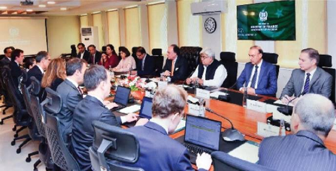 Finance ministry building in Islamabad with IMF logo on meeting room screen