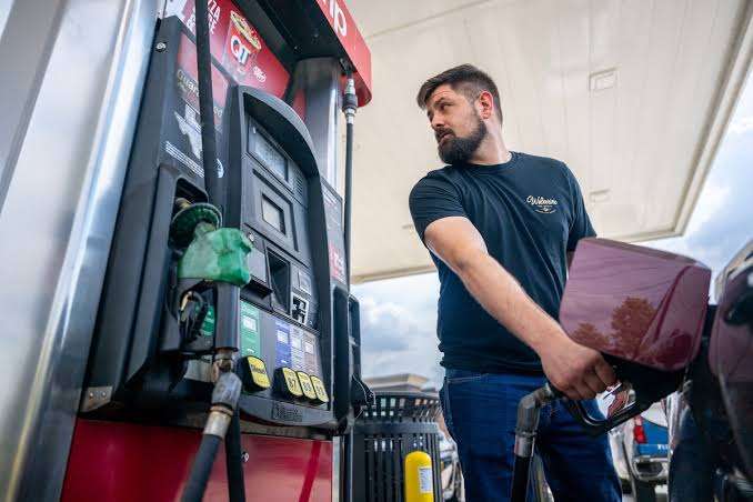 Motorist refuelling a diesel vehicle at a UK petrol station with price display showing over 200p per litre