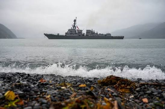USS Ted Stevens destroyer in port alongside Whittier coastline