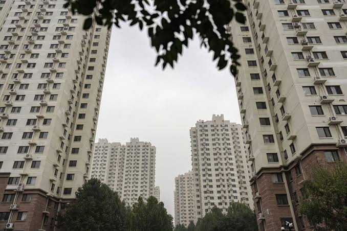 Construction cranes and unfinished residential buildings in a Chinese city