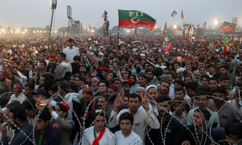 Crowds and police on a city street near Islamabad